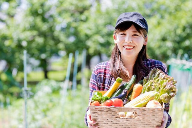 野菜が入ったカゴを持つ女性